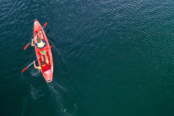 Kano nehir manzarasında yüzüyor, İHA 'nın üst görüntüsü, kanoda iki adam.