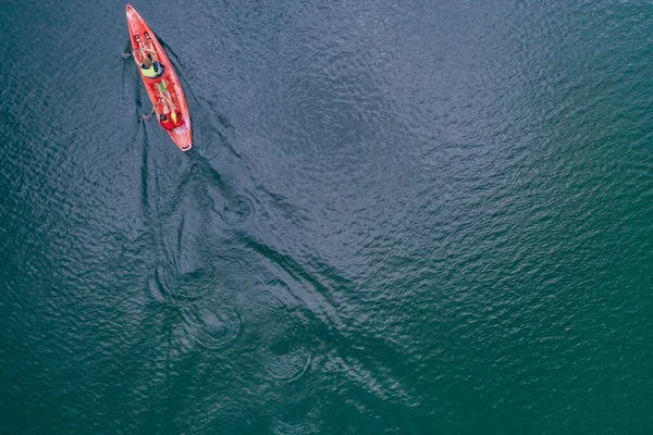Kano nehir manzarasında yüzüyor, İHA 'nın üst görüntüsü, kanoda iki adam.