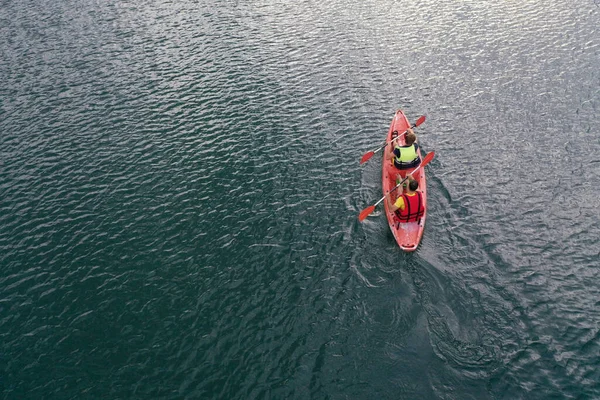 Kano nehir manzarasında yüzüyor, İHA 'nın üst görüntüsü, kanoda iki adam.