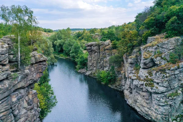 Aralarından bir ırmak geçen arge taşları ve berrak su. Ağaçlar kayalarda yetişir..