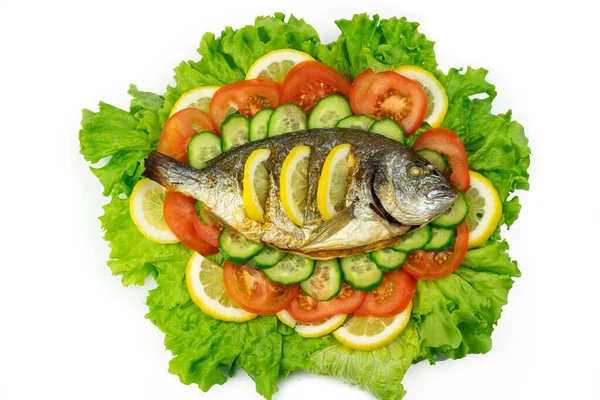 Sebzeli ızgara dorado balığı: salata, domates, salatalık, yeşil biber ve beyaz arka planda limon.