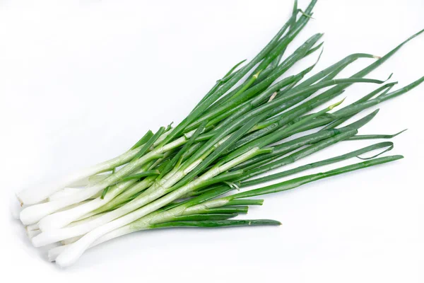 Beyaz arka planda yeşil tüylü taze soğanlar.