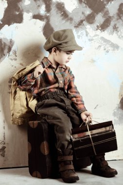 Bagaj tutan kitaplar, retro stilize atış, 50'li 60'ların üzerinde oturan çocuk