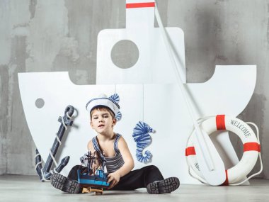 Donanma dekorasyon, stüdyo çekim kabin yakışıklı çizgili tişört ve denizci şapkası modeli geminin önünde oynamaya stilize