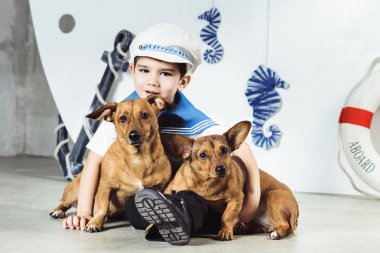 Kabin çocuk şapkalı önünde oturan çizgili tişört ve denizci gemi vurdu studio iki küçük köpeklerle stilize