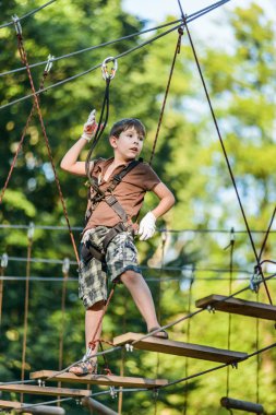 Kablo rota aşırı macera halat Parkı içinde güneşli yaz gününde geçen çocuk