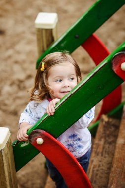 Sevimli kız çocuk parkında oynarken gülümseyen