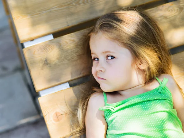 Cute Little Curly Hair Blonde Girl Lying Wooden Bench Looking — Stock Photo, Image