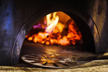 Geleneksel İtalyan tuğla pizza fırını önünde kürek