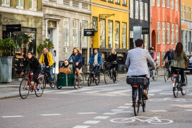 Copenhagen; Danimarka - Mayıs 03; 2018: bir grup insan eski şehir merkezinde bisiklet sürme. Sepeti el arabası kargo bisiklet önünde oturan bir adam. Hareketi her iki yönde yol işaretleri döngüsü lane. Sokak stili