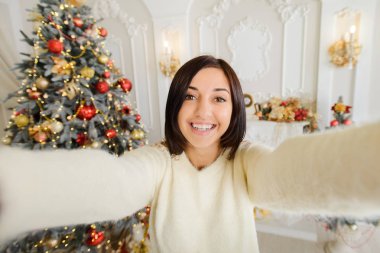 Kız cep telefonuyla noel fotoğrafı çekiyor.