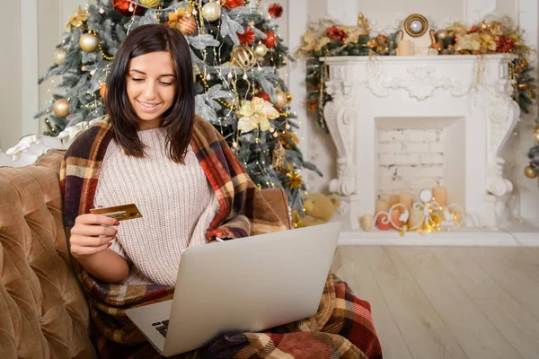 İnternetten noel alışverişi yapan, kredi kartı tutan bir kız.