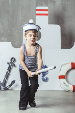 Kamarot çocuk stilize bir geminin önünde kürekle oynuyor.