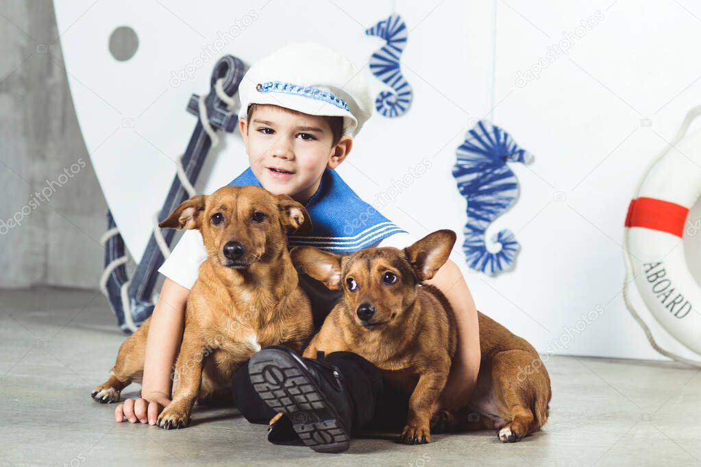 Cabin boy with two small dogs in front of ship