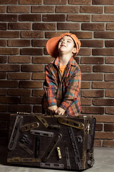 Jongen spelen werkman holding gereedschapskoffer versierd met deur hardwa — Stockfoto
