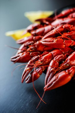 Koyu ahşap masada limonlu kırmızı kerevit.