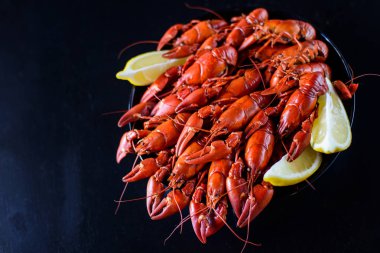 Koyu ahşap masada limonlu kırmızı kerevit.