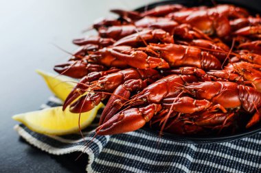 Koyu ahşap masada limonlu kırmızı kerevit.