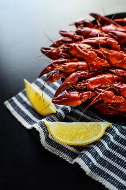 Koyu ahşap masada limonlu kırmızı kerevit.