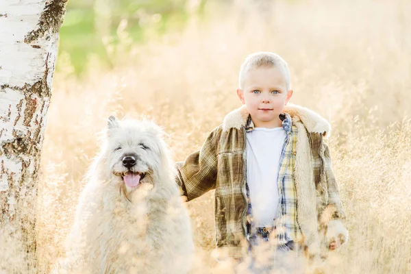 Счастливый улыбающийся блондин гуляет с собакой на ферме — стоковое фото