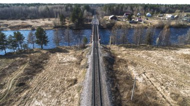İlkbaharda kırsal alanda nehrin karşısındaki demiryolu köprüsünde havadan görünüm