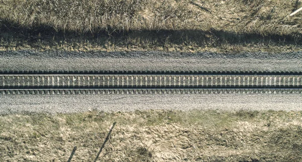 Vista aérea de un avión no tripulado alto de un ferrocarril a través del bosque de primavera. Lugares rurales —  Fotos de Stock