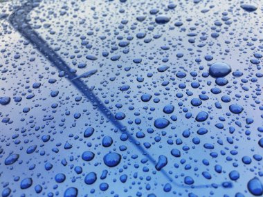 Water drops at blue car paint. Polishing and detailing cars clipart