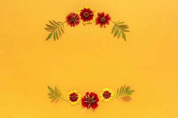 Квіткова композиція. Каркас квітковий круглий вінок з жовтих червоних квітів на помаранчевому фоні. Пласка композиція зверху вниз. Скопіювати простір Згорнути шаблон для листівки, написання тексту або вашого дизайну — стокове фото