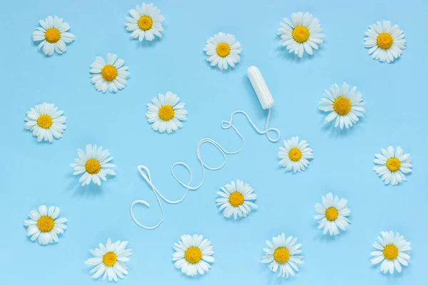 Word CLEAN from white thread hygienic female tampon and chamomiles on blue background — ストック写真