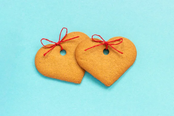 Імбирне печиво у формі серця, прикрашене бантом на синьому фоні. Вид зверху Скопіювати простір Картка Валентина — стокове фото
