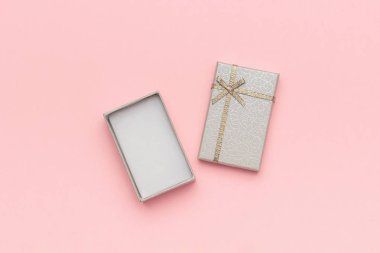 En az tarzda pembe pastel arka plan üzerinde yay ile açık gri hediye kutusu. Üstte Görüntüle Kopyalama alanı Mockup