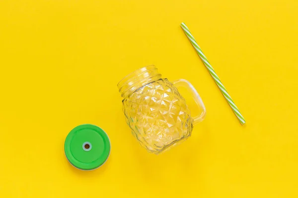 Άδειο γυάλινο βάζο σε μορφή ανανά με πράσινο καπάκι και άχυρο για χυμούς φρούτων ή λαχανικών, κοκτέιλ και άλλα ποτά σε κίτρινο φόντο. Κορυφαία προβολή πρότυπο χώρου αντιγραφής — Φωτογραφία Αρχείου