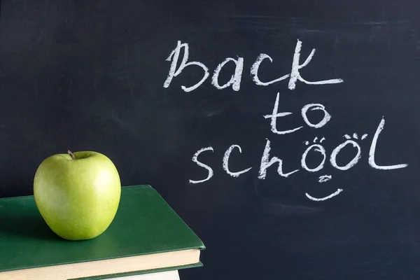 Felirat szöveg vissza az iskolába, fekete Chalkboard és a zöld alma a verem könyvek tankönyvek, koncepció oktatás — Stock Fotó