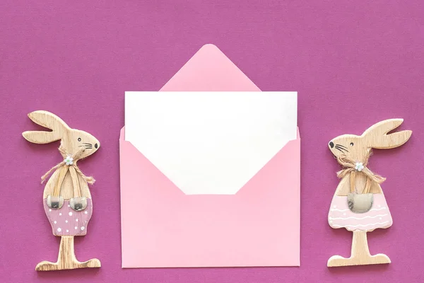 Composition romantique Paire d'amoureux du bois figurine lapins et enveloppe rose avec carte blanche sur fond violet Concept Valentine's card Vue du dessus Mockup Flat Lay — Photo