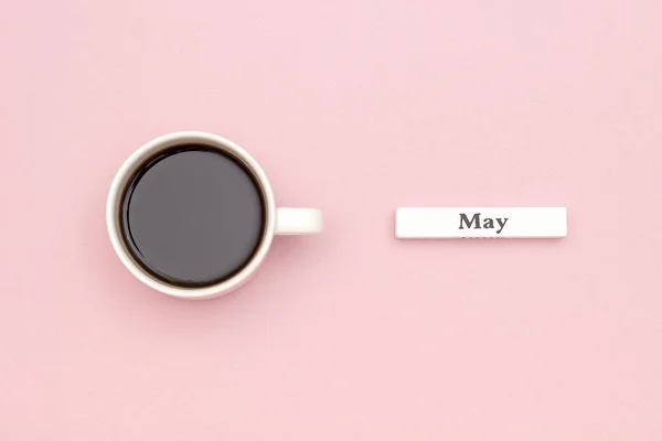 Calendario de madera mes de primavera mayo y taza de café negro sobre fondo de papel rosa pastel. Concepto Hello May Creative Vista superior Flat Lay Tarjeta de felicitación —  Fotos de Stock