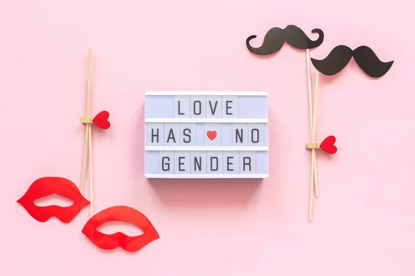 Lightbox text Love has no gender, couple paper mustache lips props on pink background. Concept Homosexuality gay love National Day Against Homophobia or International Gay Day Top view Greeting card
