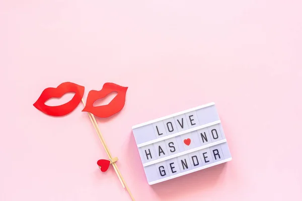 Lightbox text Love has no gender, couple paper lips props on pink background. Concept lesbian love National Day Against Homophobia or International Gay Day Top view Greeting card