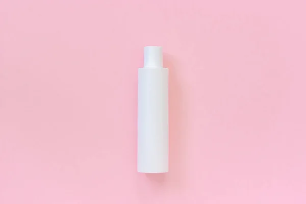 一个空白的白色塑料化妆品瓶洗发水，化妆水，奶油或其他化妆品在粉红色背景。模板或模拟为您的设计。复制空间 顶部视图 — 图库照片
