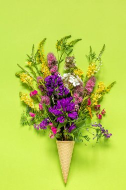 Yeşil kağıt arka plan Düz Lay Top view Mock up Concept Women's day or Mothers Day waffle dondurma koni buket alan renkli çiçekler