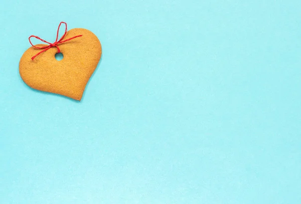 Galletas de jengibre en forma de corazón decoradas con un lazo sobre un fondo azul. Vista superior Copiar espacio Tarjeta San Valentín —  Fotos de Stock