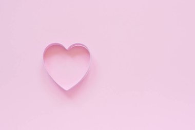 Pastel pembe arka planda kalp şeklinde kesici kurabiyeler. Konsept Sevgililer Kartı. Üst görünüm Metin için kopya alanı