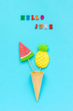 Merhaba Haziran renkli metin, ananas ve karpuz lolipop dondurma waffle koni mavi kağıt arka plan üzerinde. Kavram tatil veya tatilCreative Top view Şablon Tebrik kartı, kartpostal