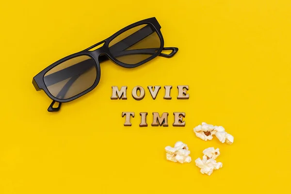 3D brýle, popcorn a texty čas filmu na žluté pozadí papíru. Pohled shora šablona koncept filmový film a zábava — Stock fotografie