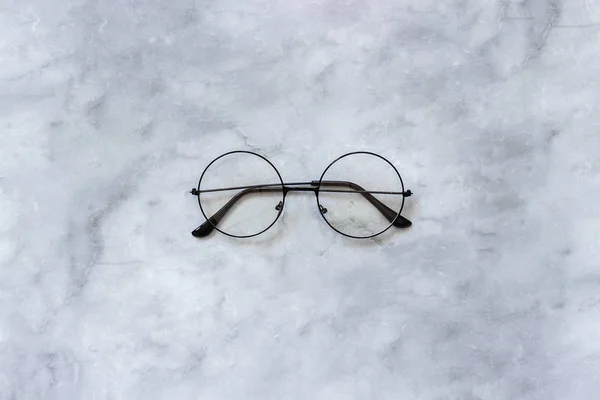 Lunettes rondes noires élégantes sur fond de marbre. Vue du dessus Espace de copie Style minimal — Photo