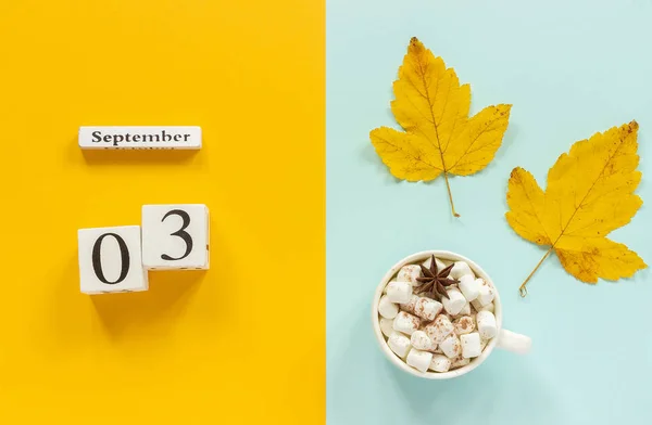 Composição do outono. Calendário de madeira 3 de setembro, xícara de cacau com marshmallows e folhas de outono amarelas no fundo azul amarelo. Visão superior Flat lay Conceito Mockup Olá Setembro — Fotografia de Stock