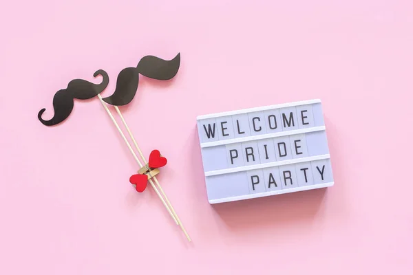 Lightbox text Welcome pride party and couple paper mustache props on pink background. Concept Homosexuality gay love National Day Against Homophobia or International Gay Day Top view Card invitation