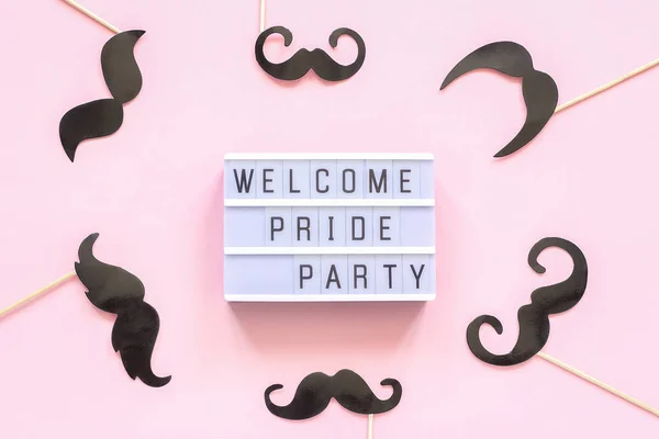 Lightbox text Welcome pride party and paper mustache props on pink background. Concept Homosexuality gay love National Day Against Homophobia or International Gay Day Top view Card invitation