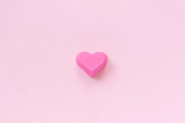 Stampo a forma di cuore in silicone per cuocere cupcake su sfondo di carta rosa. Modello per lettering, testo o il vostro disegno Vista dall'alto, spazio di copia Stile minimo — Foto Stock