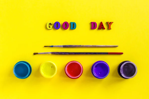 Text Guten Tag, Gläser mit Gouache und Pinsel auf gelbem Rücken — Stockfoto
