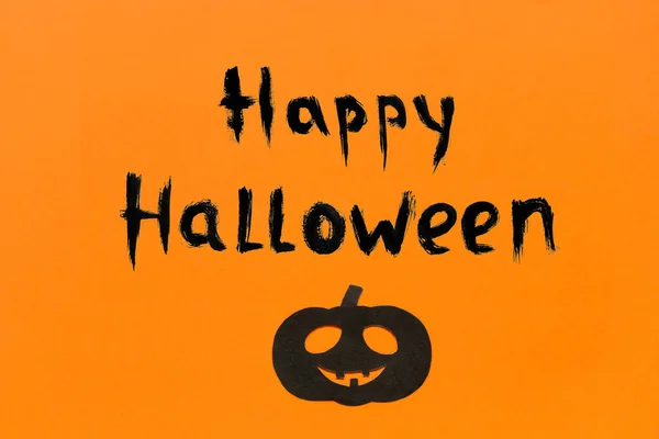 Tło Halloween. Tekst napis Happy Halloween czarny papier dyni na pomarańczowym tle — Zdjęcie stockowe